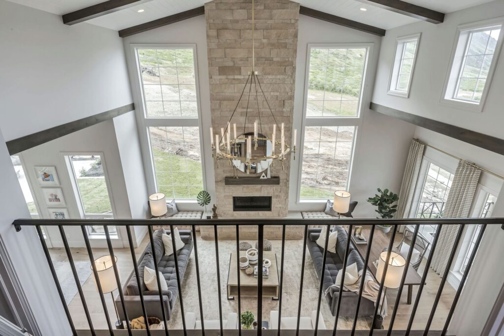 Captivating aerial view of home stairs, revealing a warm living room with fireplace and balcony.