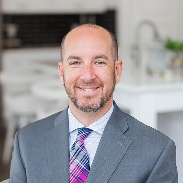 A smiling Mortgage Consultant, Steve Lundwall, in a suit and tie, posing for the camera.