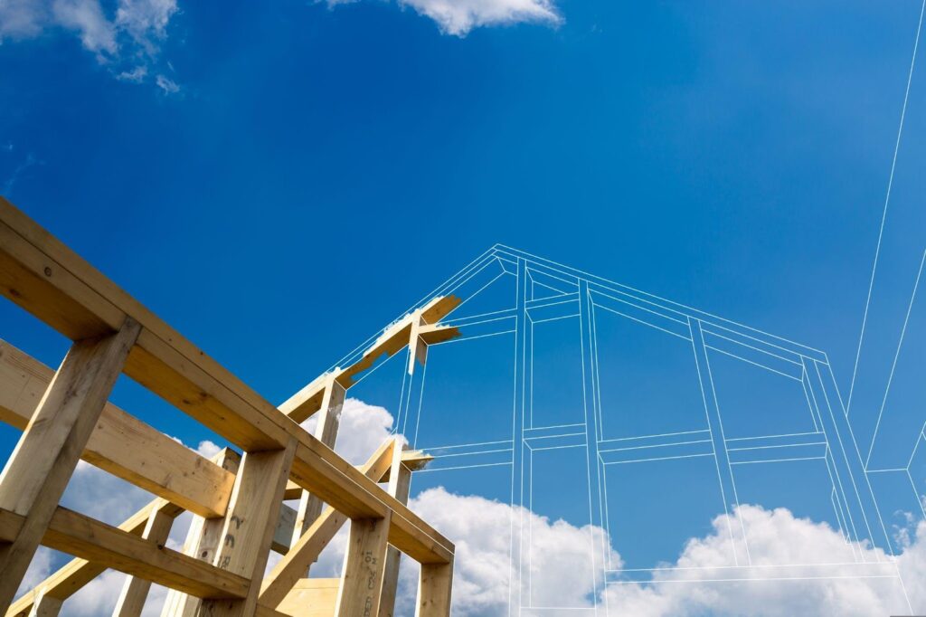 A house under construction against a backdrop of blue sky and clouds