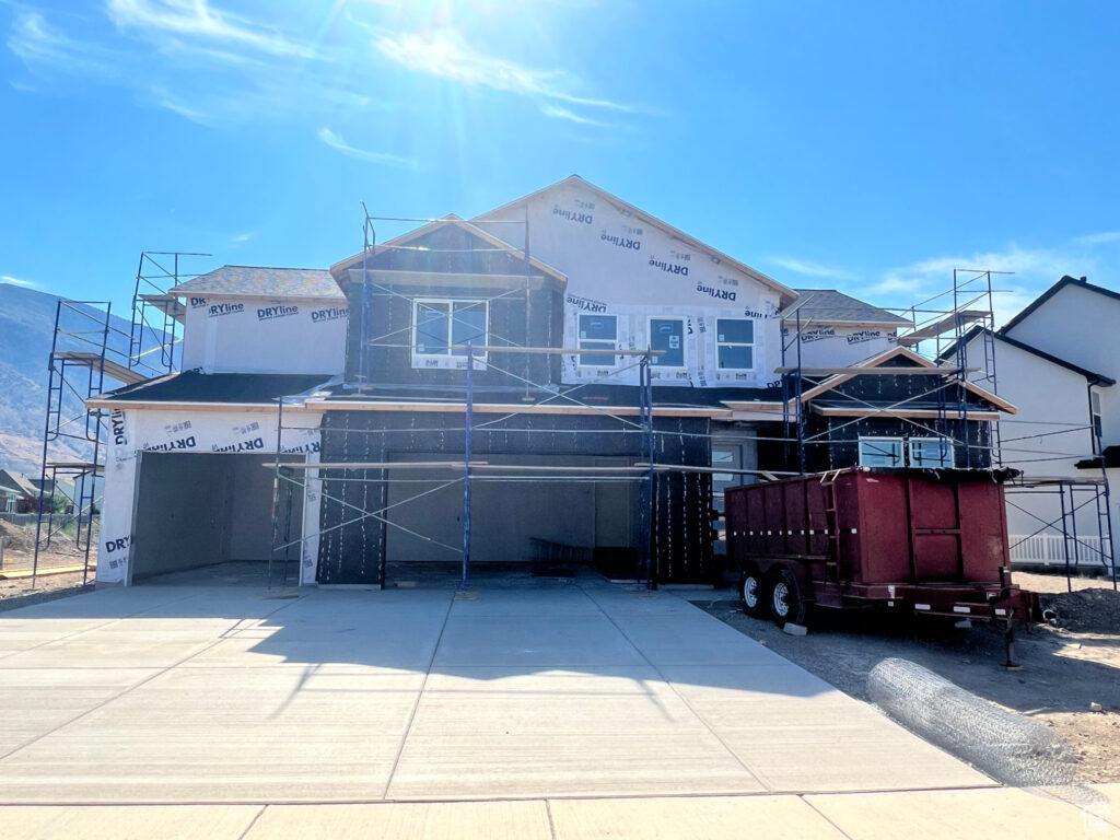Construction site with a partially built house under a clear blue sky.