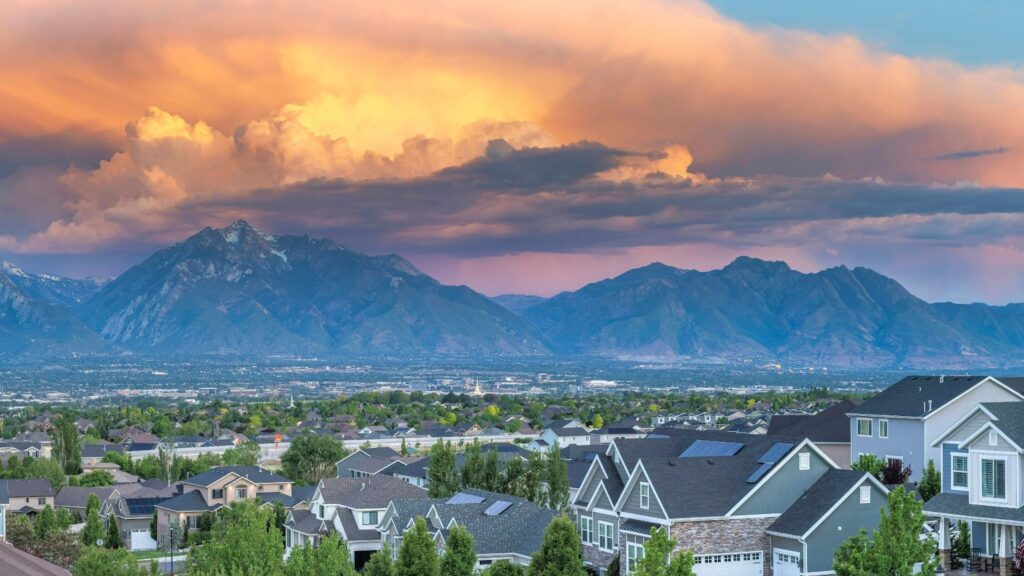 A stunning sunset over a city with mountains in the background.