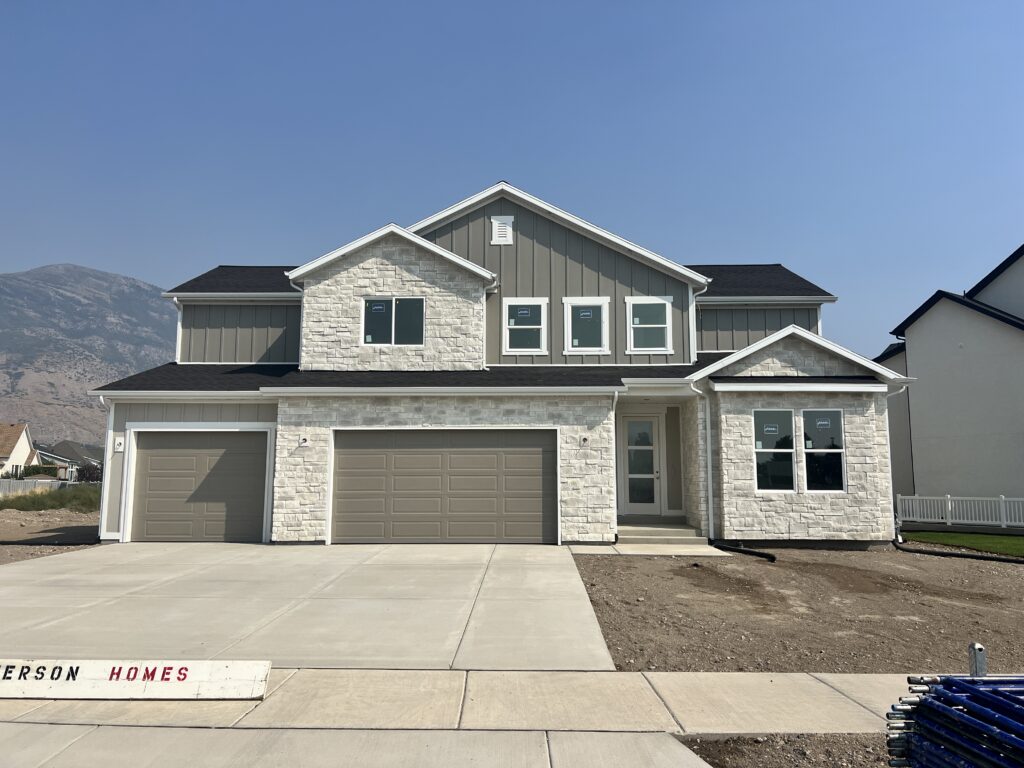 A charming home with an integrated garage and a spacious driveway, highlighting a practical and inviting residential design.