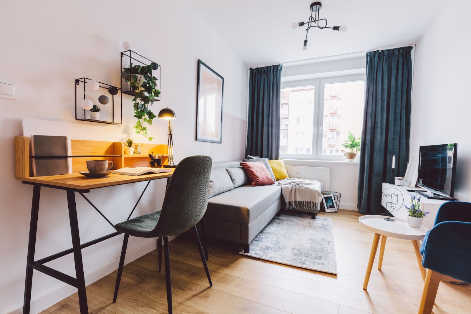 A cozy small apartment featuring a desk, chair, and a comfortable couch, creating a functional living spac