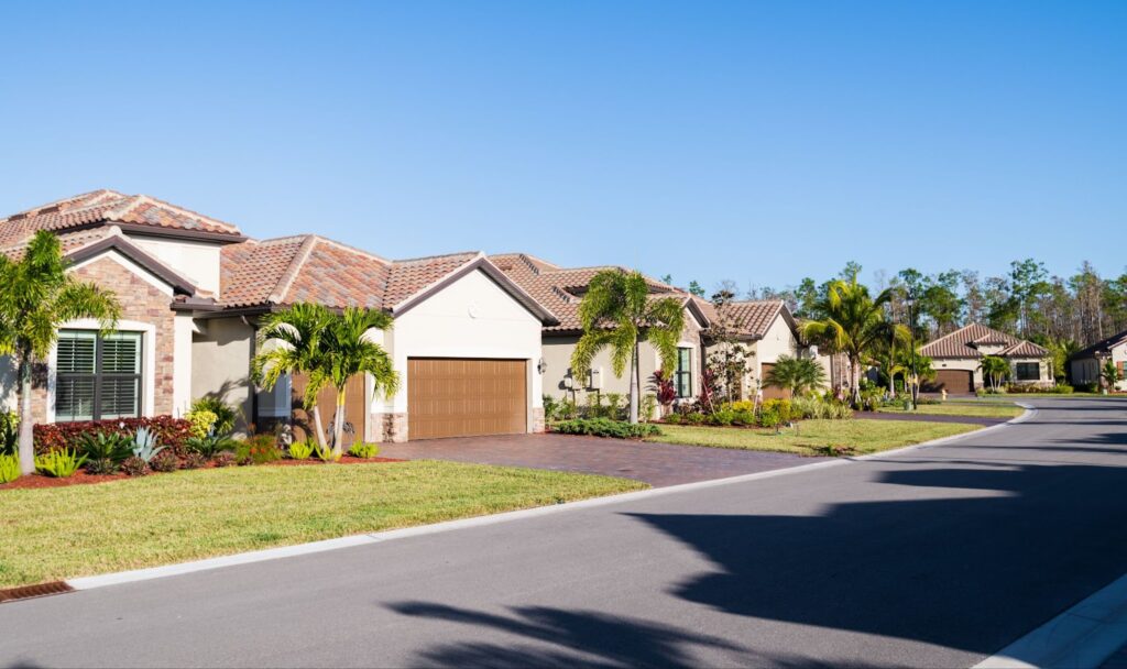 A serene residential neighborhood featuring palm trees and a driveway, showcasing modern amenities in new home communities.