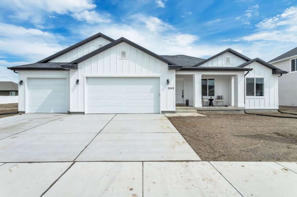 A newly constructed home featuring a driveway and garage, ideal for quick move-in opportunities.