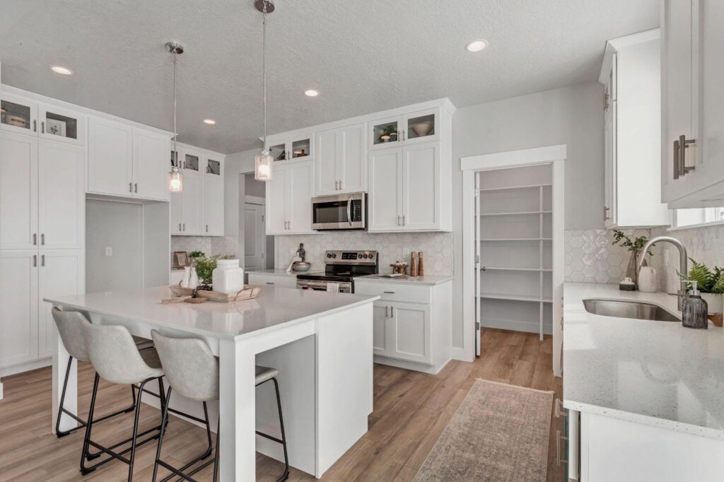 A pristine kitchen with white cabinets and a central island, showcasing a modern cooking space