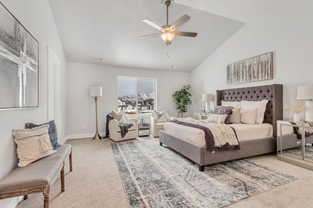 A cozy bedroom showcasing a large bed and a ceiling fan, enhancing the room's comfort and style