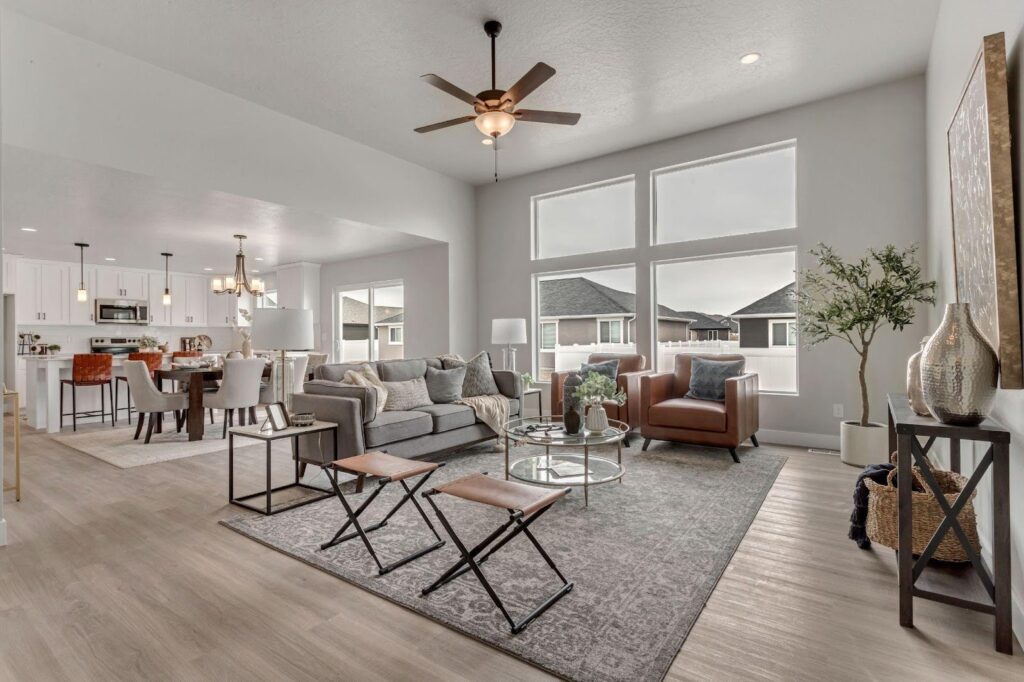 A spacious, light-filled living room with a ceiling fan and open layout