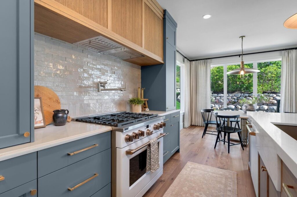 A stylish kitchen with blue cabinetry and white appliances for a contemporary design