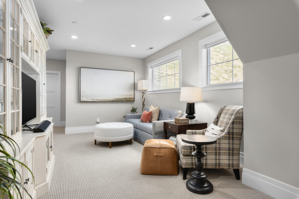 A luxurious living room featuring a stylish couch, elegant chair, and a modern television, showcasing exquisite home design.